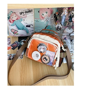 Détail d'un sac bandoulière orange avec une fenêtre transparente pour badges anime