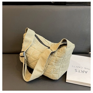 Detail view of the light olive green quilted tote bag with wide shoulder strap