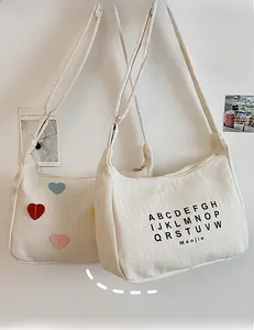 Close-up of cream canvas tote bag showing herringbone texture and zipper closure details
