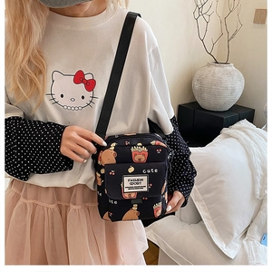 Détail du petit sac bandoulière noir avec motifs de dessins animés mignons