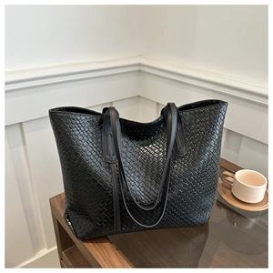 Close-up of black woven leather tote bag texture on a wooden table for daily commute