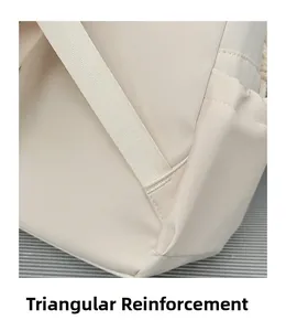 Detail of triangular reinforced stitching on off-white synthetic leather backpack strap
