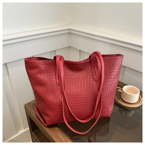Macro detail of deep red woven leather tote bag with elegant checkered texture