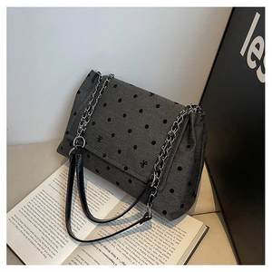 Détail du sac cabas gris à pois avec bandoulière en chaîne et motif à nœuds