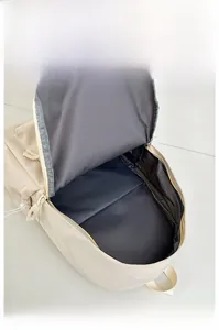 Internal view of beige backpack showing spacious main compartment with grey fabric lining