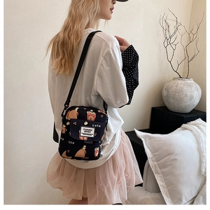 Détail du sac bandoulière noir en toile avec motifs de petits ours et cerises mignons