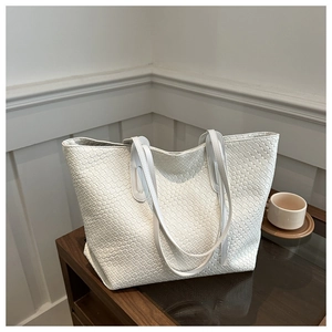 Detail of white woven tote bag texture with vegan leather straps and spacious interior