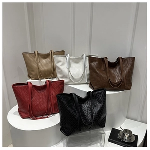 Detailed view of woven leather tote bags in khaki, white, coffee, red, and black colors