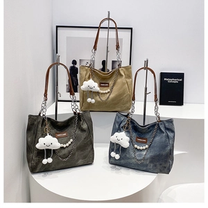 Détail de sacs cabas en toile en kaki, anthracite et bleu denim avec anses en cuir