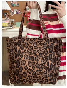 Close-up of leopard print tote bag with dual handles in a cozy home lifestyle setting