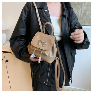 Detail view of khaki mini butterfly backpack with silver hardware and chic top handle