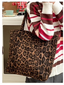 Detailed shot of large leopard print tote bag with wide shoulder strap on model shoulder