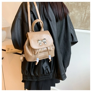 Detail of khaki PU leather butterfly backpack with silver bow and drawstring beads