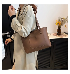 Brown leather tote bag featuring a front envelope pocket with metal button buckle