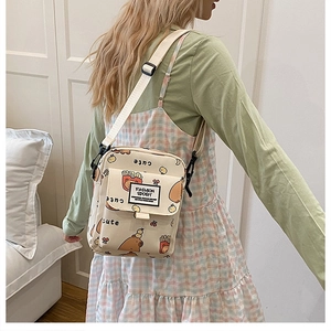 Détail du sac bandoulière en toile avec motifs d'ours et sangle en nylon réglable pour femme