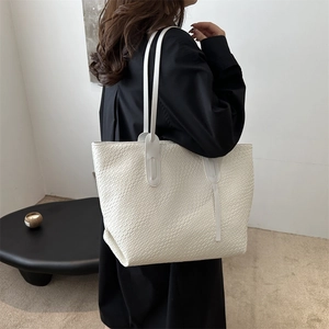 Minimalist white woven tote bag with slim shoulder straps for daily commute style