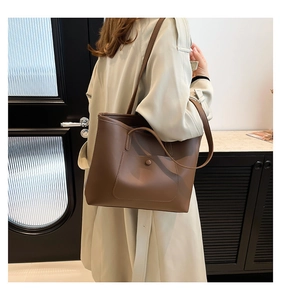 Macro view of brown leather tote bag with functional front snap pocket for daily commuting