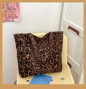 Detailed close-up of a large leopard print canvas tote bag with durable dual handles