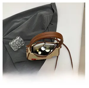 Top view of woven beige crossbody bag showing interior capacity for phone and cosmetics