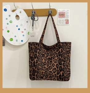 Detail of large leopard print canvas tote bag hanging on a wooden wall hook