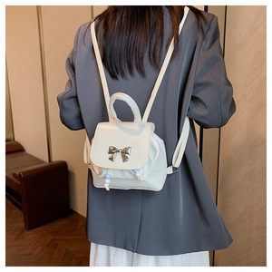 Detail of white butterfly mini backpack with silver bow and drawstring on model