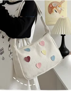 Close-up of canvas crossbody bag showing herringbone texture and colorful heart patches