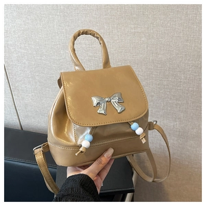Close-up of khaki mini PU backpack with silver butterfly buckle and bead drawstring