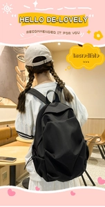 Rear view of a black minimalist nylon backpack on a model in a cozy cafe setting