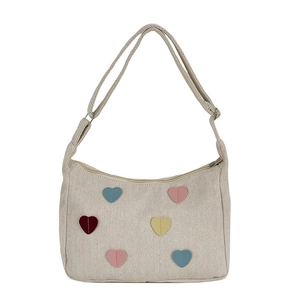 Off-white canvas hobo bag with colorful heart embroidery and adjustable shoulder strap
