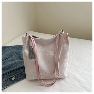 Detail of elegant Chinese style jacquard tote bag featuring floral patterns and a long tassel