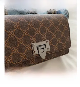 Detail of vintage leopard print handbag with silver metal push-lock and textured leather finish