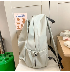 Detail of the light grey-green waterproof nylon backpack with drawstring side pocket