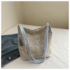 Detail of blue Oriental embroidery shoulder bag with traditional tassels and landscape pattern