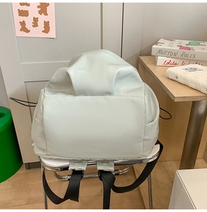 Detailed side view of the light green casual backpack featuring black adjustable straps