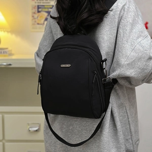 Fashionable black nylon backpack with large capacity for women on indoor home background
