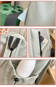 Detail of light gray backpack showing reinforced handle and side pockets for storage