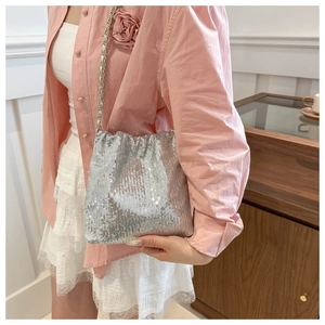 Close-up of sparkling silver sequin handbag with elegant gold and silver chain strap