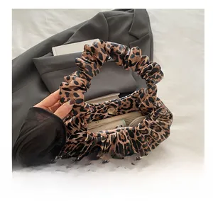 Detail view of the leopard print crescent bag interior showing magnetic closure and storage