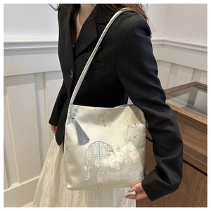 Detail view of oriental embroidery tote bag with classic floral motifs and grey tassel decor