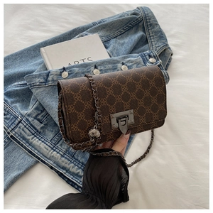 Detailed view of the brown vintage crossbody bag with clover pattern and metal chain