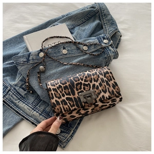 Close-up of leopard print crossbody bag featuring metal chain strap and square lock