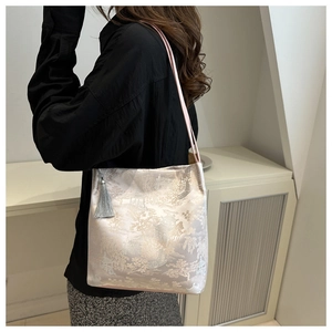 Detail of floral jacquard satin shoulder bag with long grey tassel and pink slim strap