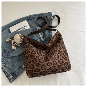Detailed top view of a vintage leopard print bucket bag with a cute kitten pendant accessory