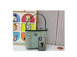 Detailed size comparison of the light green canvas bucket bag next to a mobile phone