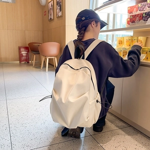 Detail view of large cream campus backpack featuring waterproof nylon and side pockets