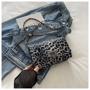 Close-up of black and grey leopard print crossbody bag with metallic chain and buckle