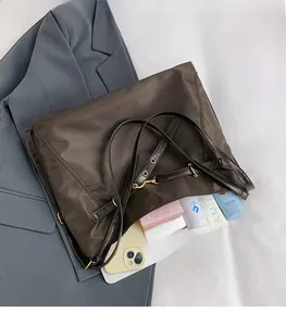 Macro view of the deep brown nylon tote bag showing spacious interior and golden hardware
