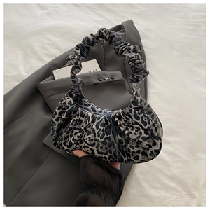 Detail of leopard print crescent bag with pleated handle and ruched stylish design