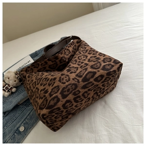 Close-up of leopard print shoulder bag in suede texture with dark brown leather straps