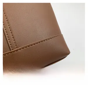 Close-up of premium brown lychee grain leather with durable double-stitched corner detail